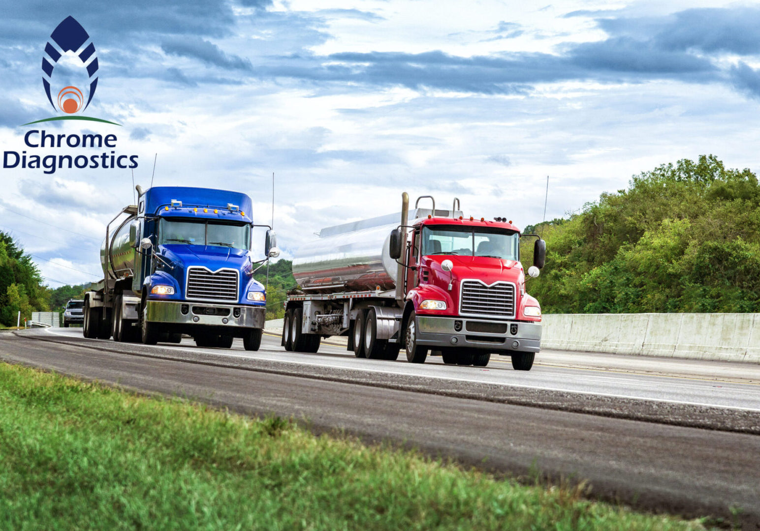 Horizontal shot of two gasoline tanker trucks on the interstate.  One has a red cab and the other a blue cab.  Cloudy sky.